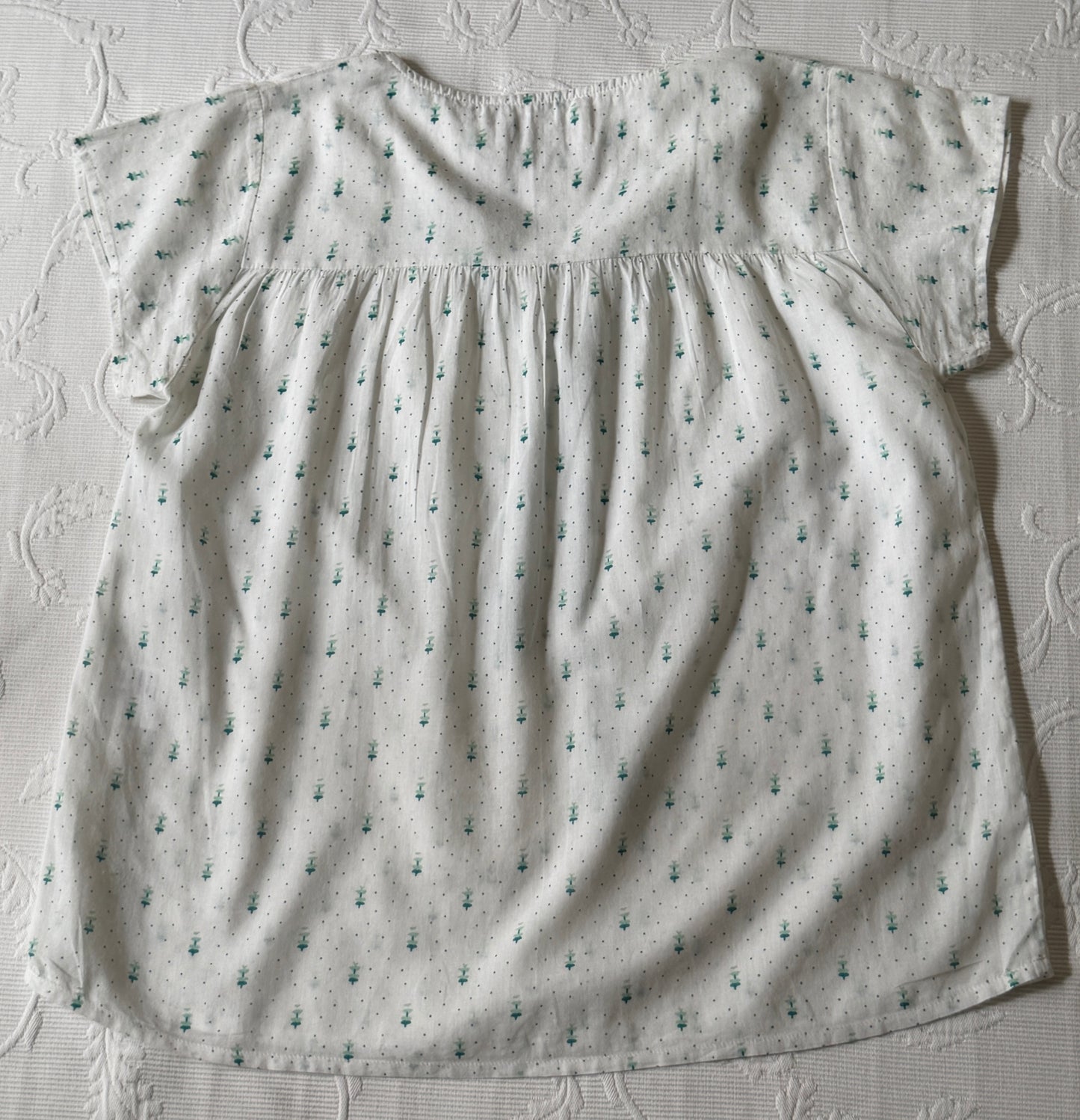 White short-sleeved blouse with green patterns