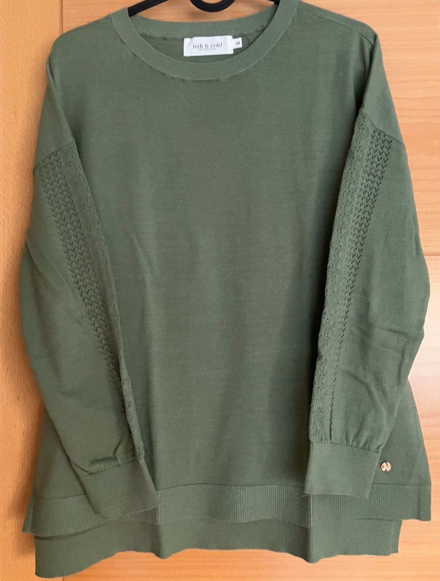 Green sweater with openwork detail on sleeves