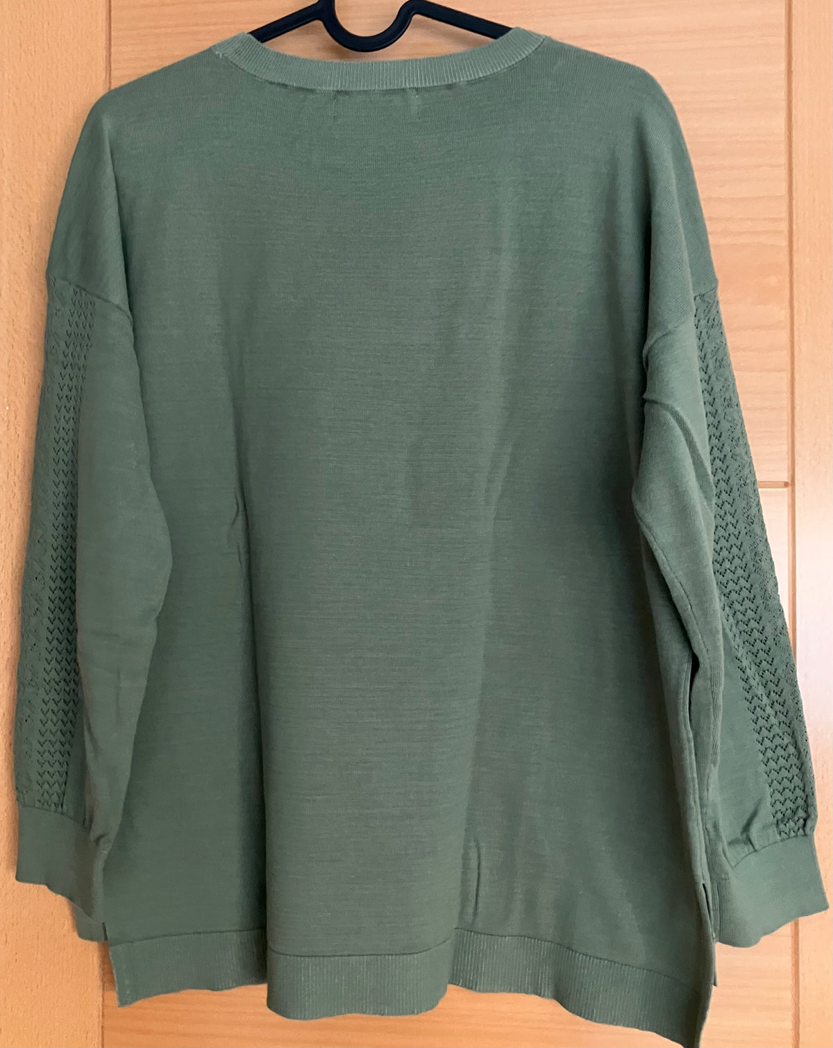 Green sweater with openwork detail on sleeves