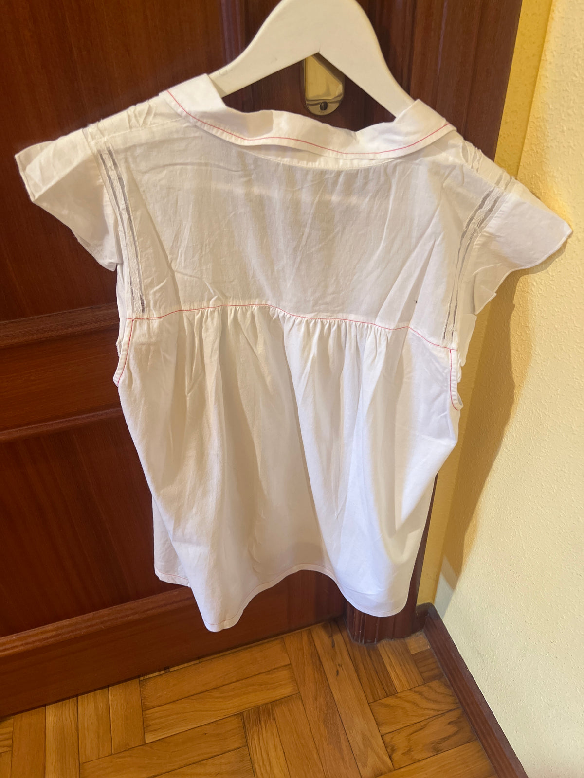 Camisa blanca con transparencias y detalles rojos