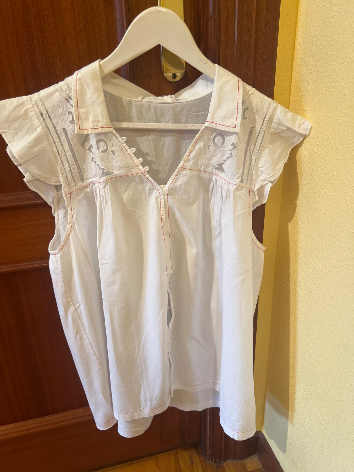 Camisa blanca con transparencias y detalles rojos